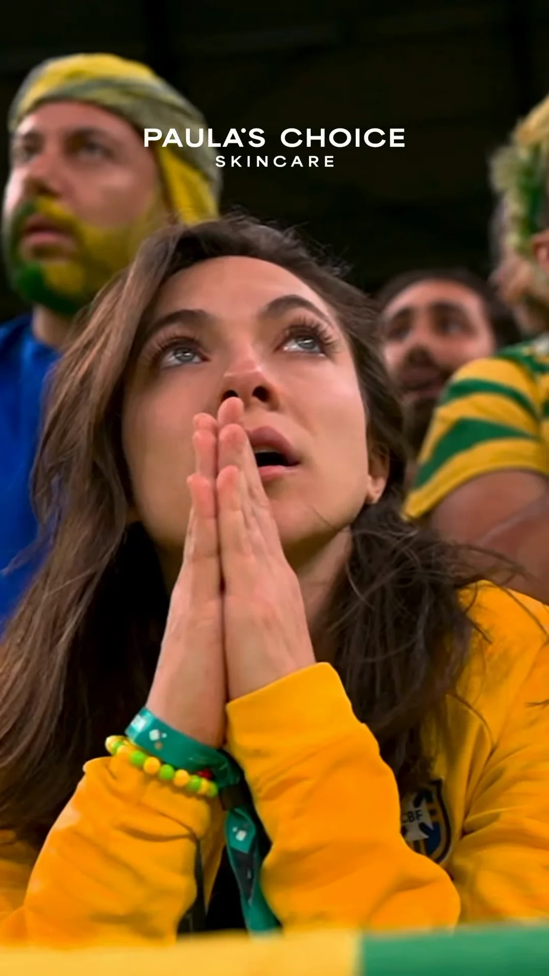 A woman in Brazil colors watching the match, from Paula’s Choice’s official World Cup campaign film