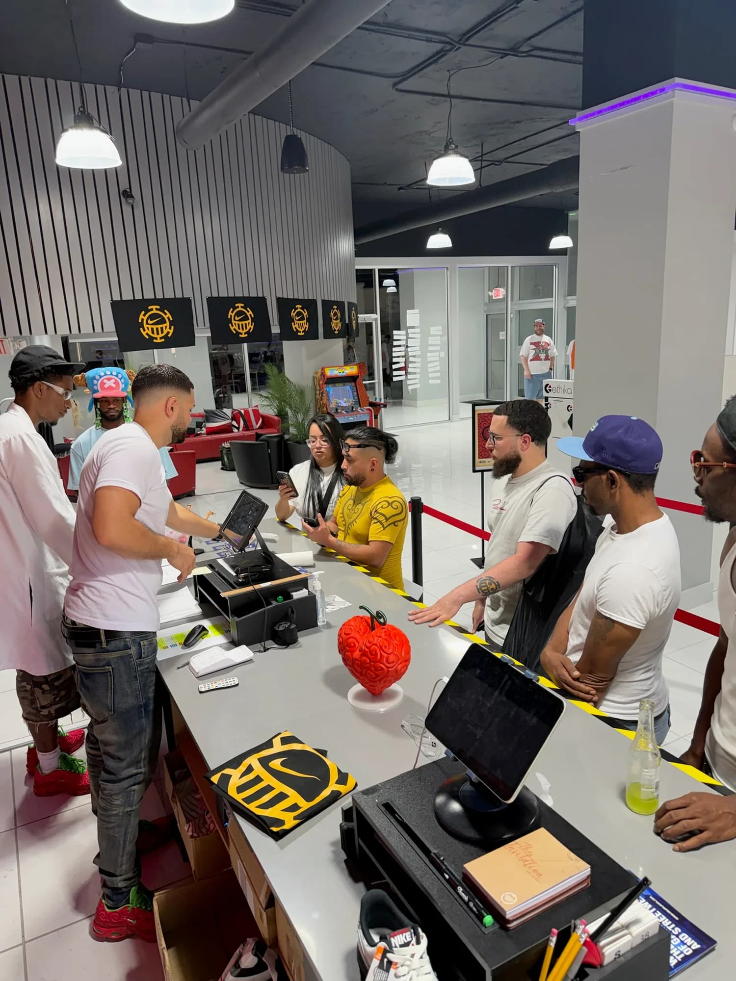 People gathered around Sole Play’s counter with One Piece hats, artwork, and a Devil Fruit display