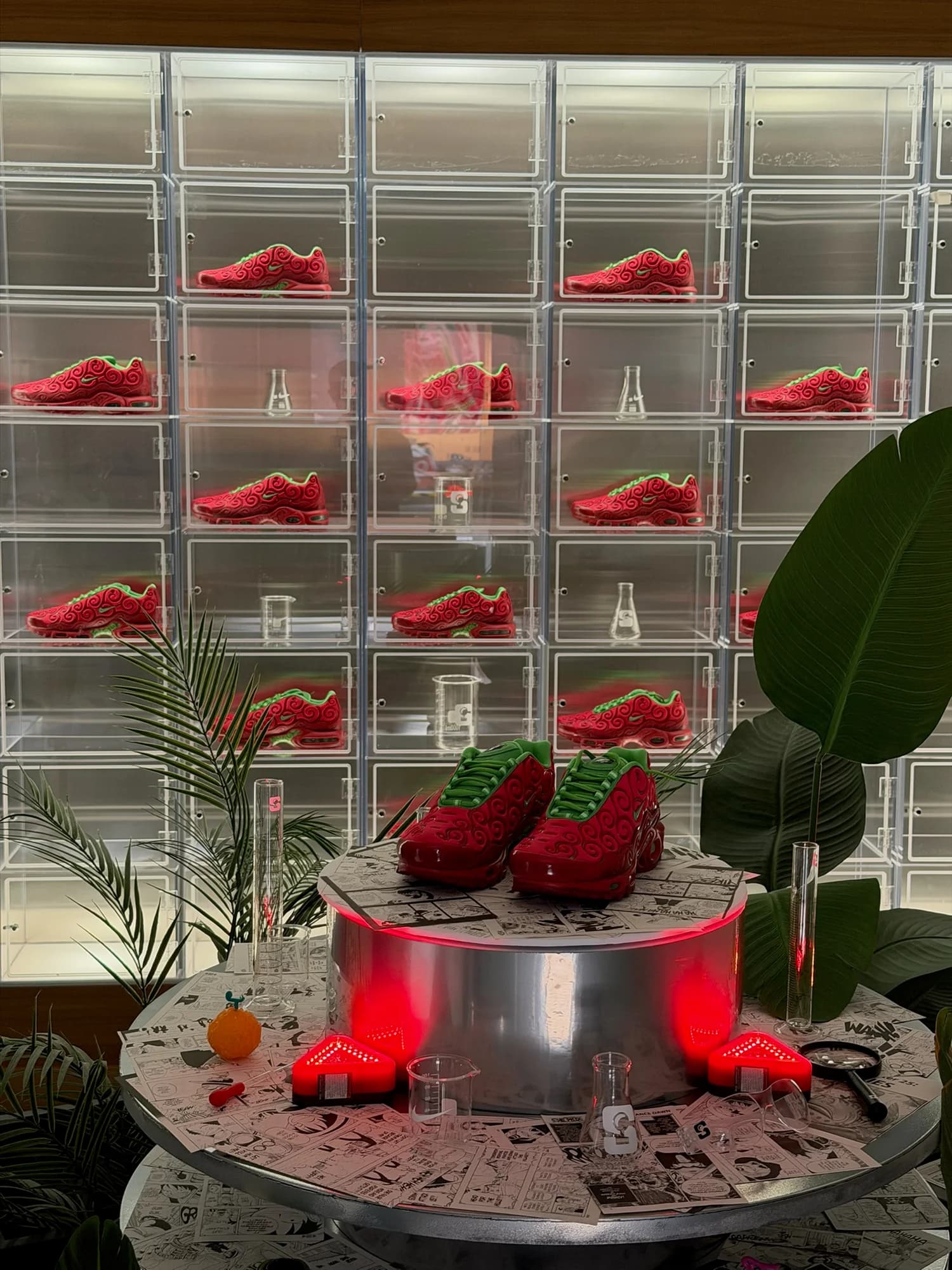 Nike × One Piece Air Max Plus shoes displayed on a manga-covered pedestal inside Sole Play