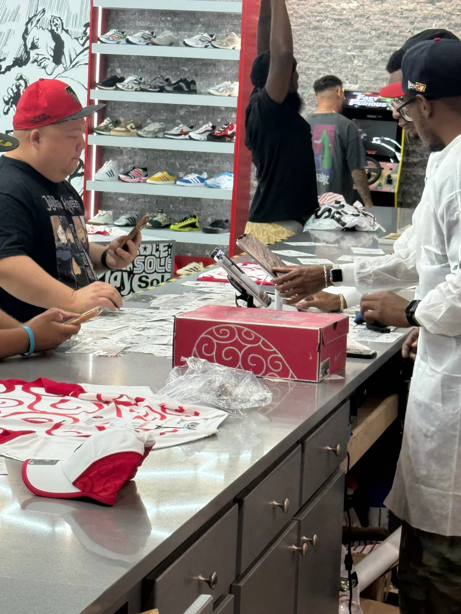 A customer and store team member at Sole Play’s manga-covered counter beside a red Nike One Piece shoebox