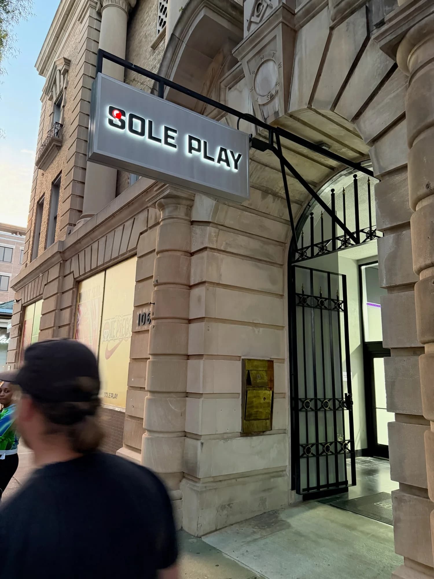 Sole Play’s hanging storefront sign above the entrance of a stone-fronted building
